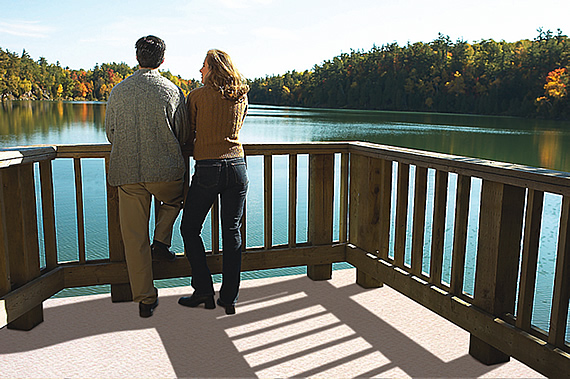 Couple standing on a DeckRite vinyl walkout deck overlooking a lake