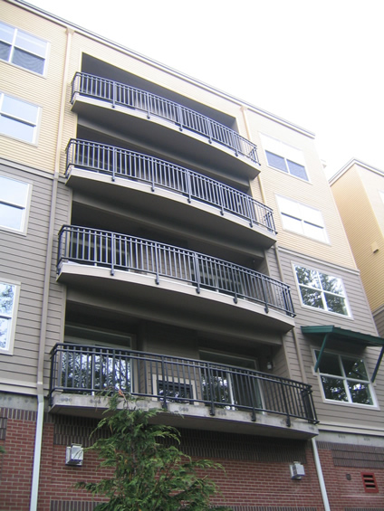 Curved stacked condominium balconies with black metal rails
