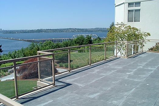 Gray vinyl deck with a glass rail overlooking a waterway