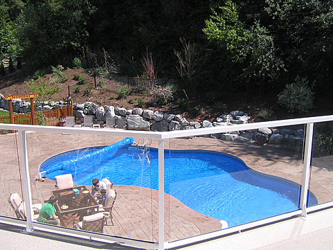 View from a balcony rail down to a kidney-shaped pool and patio